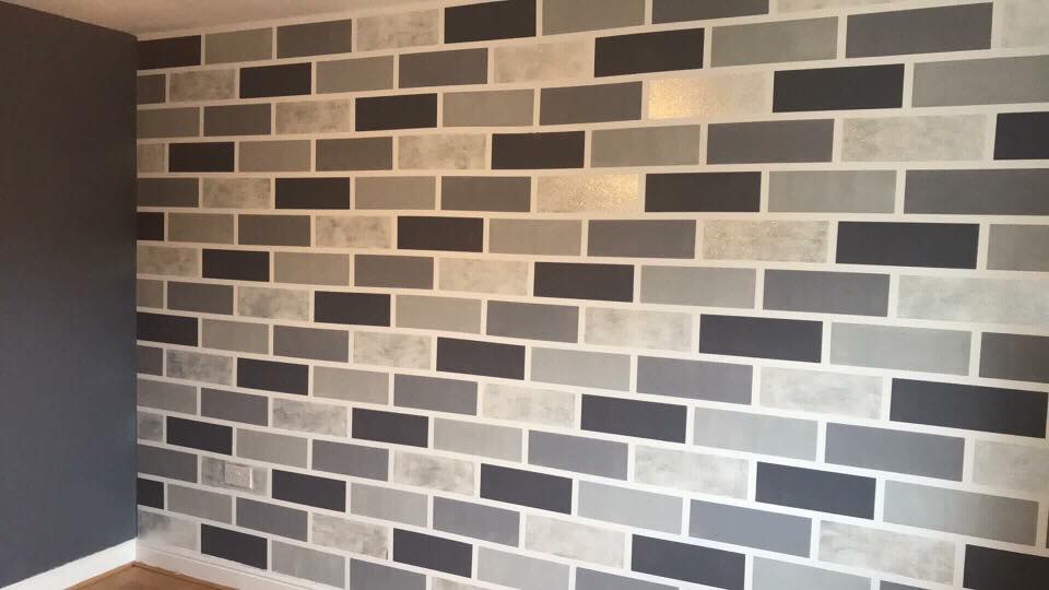 Wall painted in grey emulsion in the style of bricks. 