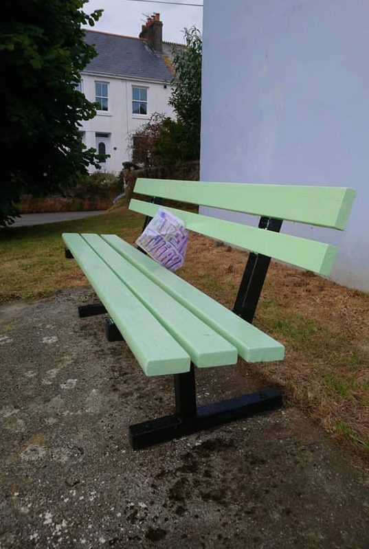 A painted park bench in pale green seat and black legs. Upcycled by a volunteer using low cost and eco paint from Community RePaint Cornwall.