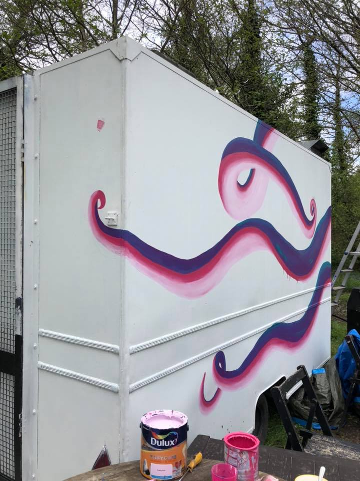 The Scarlet Jade Art painted food truck. The background is white and on top is a large octopus in purple and pink.