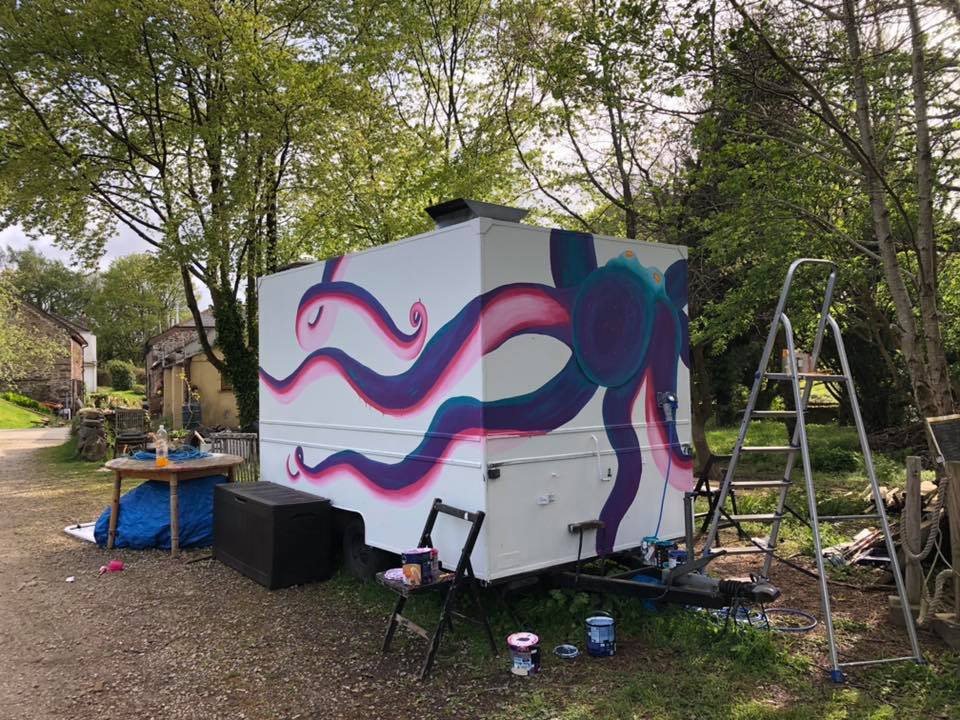 The Scarlet Jade Art painted food truck. The background is white and on top is a large octopus in purple and pink.