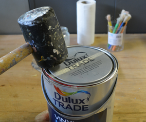 Firmly replacing the lid on a paint container