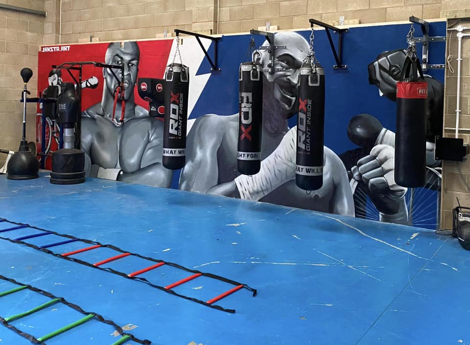 Boxing mural with boxing equipment and apparatus in a boxing gym. 